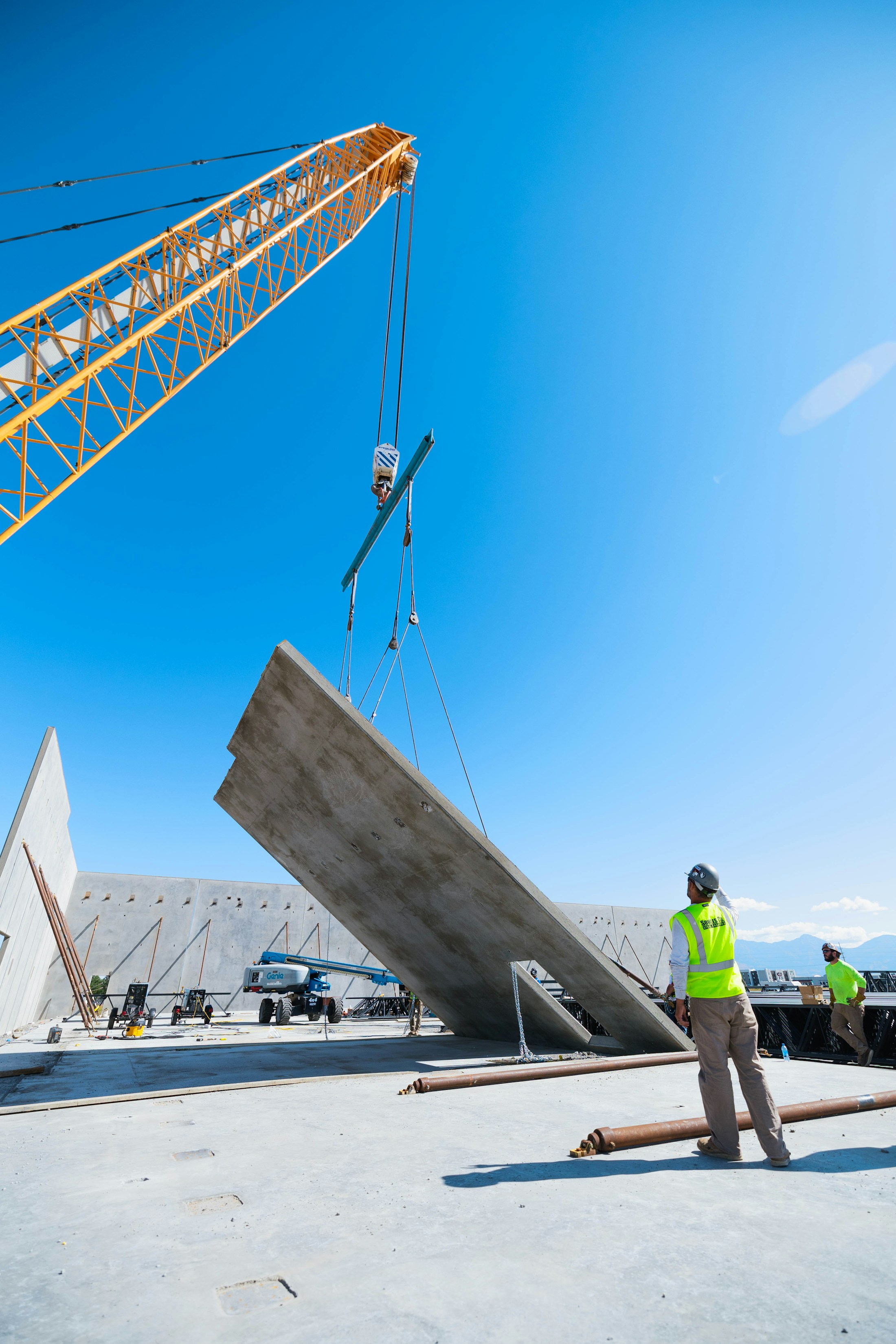 Crane lifting a precast concrete wall panel during installation