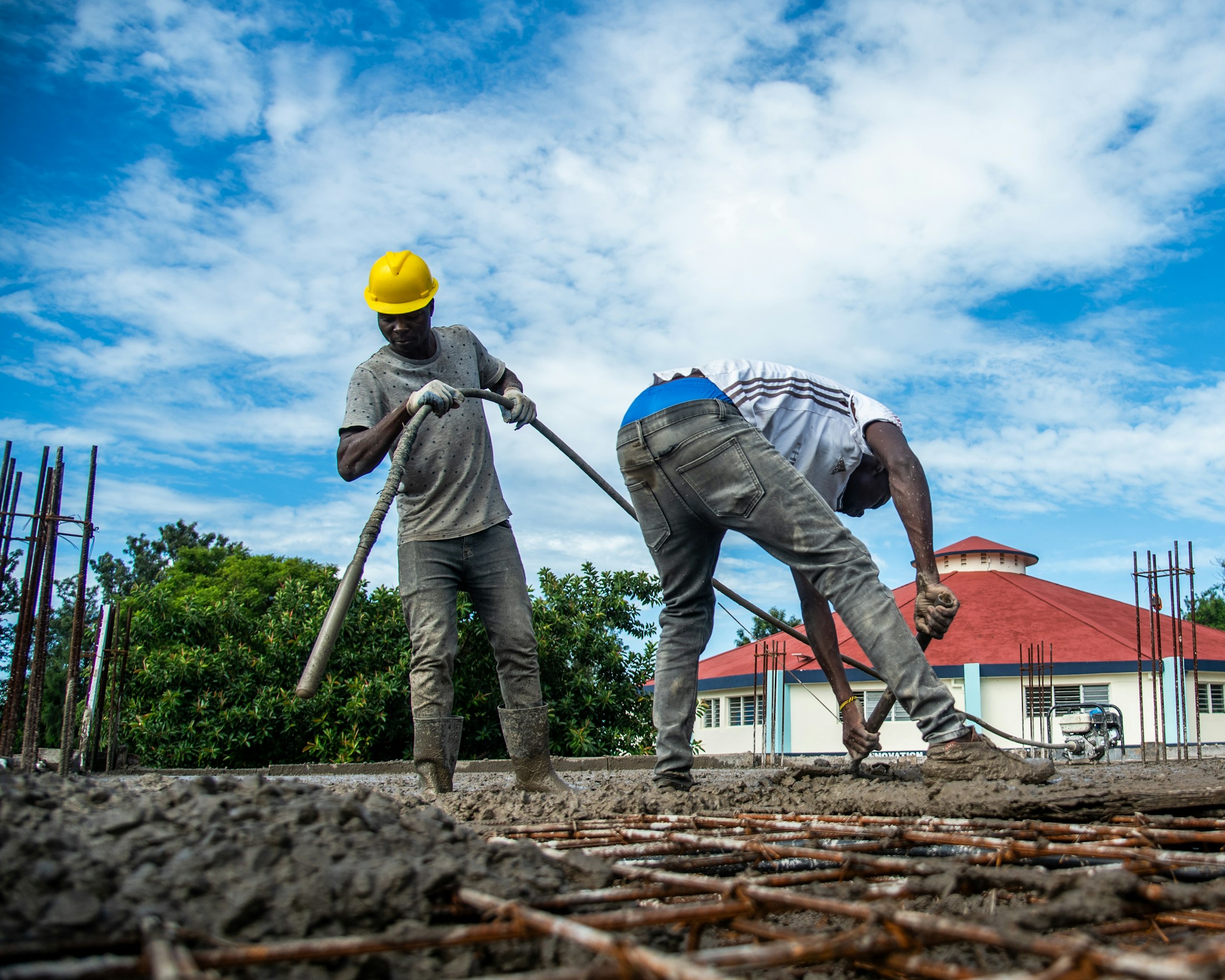 Construction team placing concrete on reinforced foundations